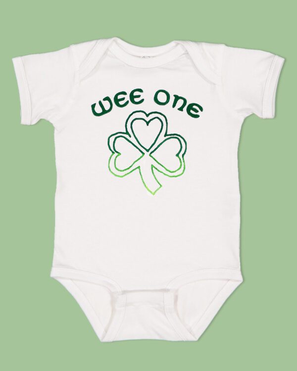 White onesie with the text 'wee one' on the front center with a shamrock below