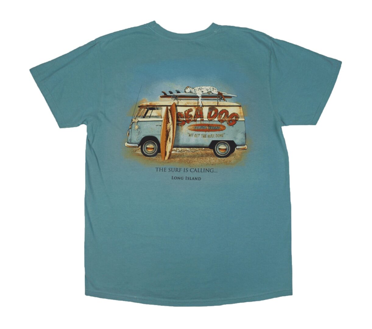 a seafoam color tee with a vw type of bus facing left with a surfboard leaning against the side of the front side door. a dalmation dog lays sleeping on the top of the van with the words sea dog across the body of the van. the words 'the surf is calling' is below the van with the words 'long island' below that.